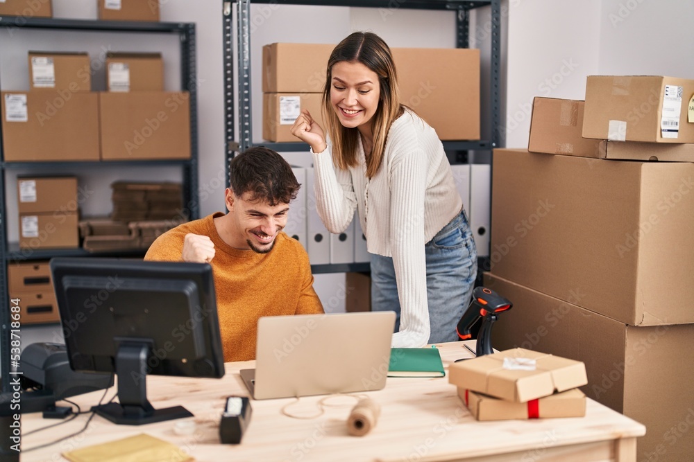Young couple working at small business ecommerce screaming proud, celebrating victory and success very excited with raised arm Young couple working at small business ecommerce screaming proud, celebrating victory and success very excited with raised arm