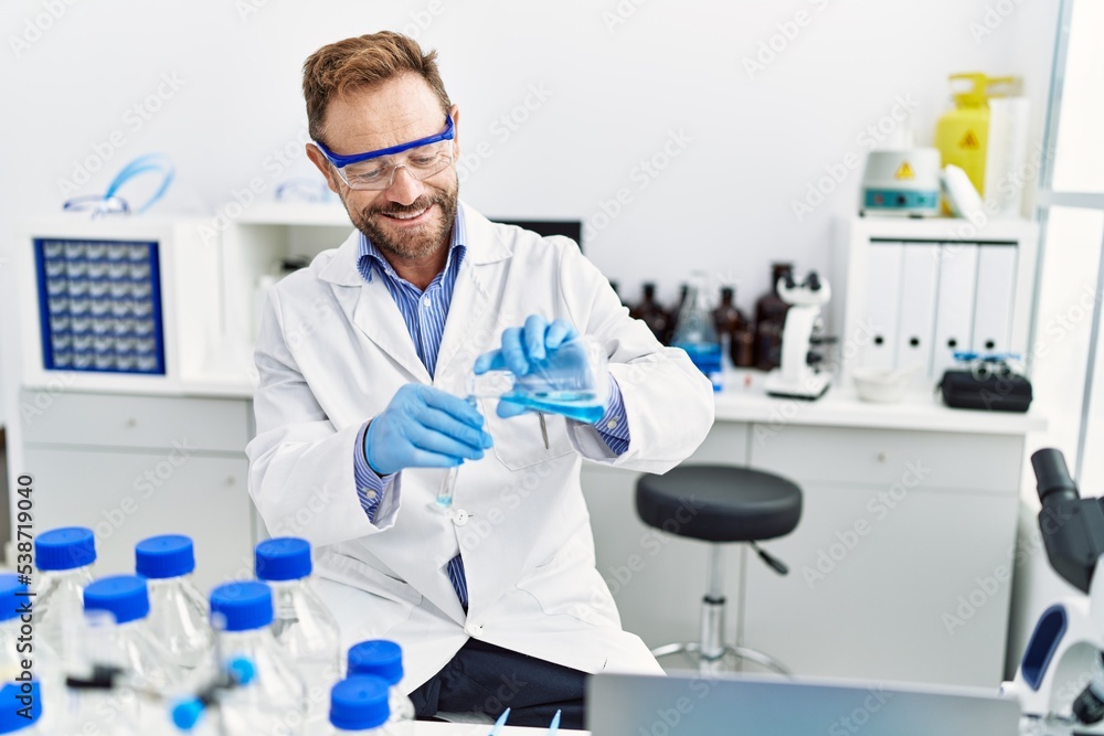 Middle age hispanic man wearing scientist uniform working at laboratory Middle age hispanic man wearing scientist uniform working at laboratory