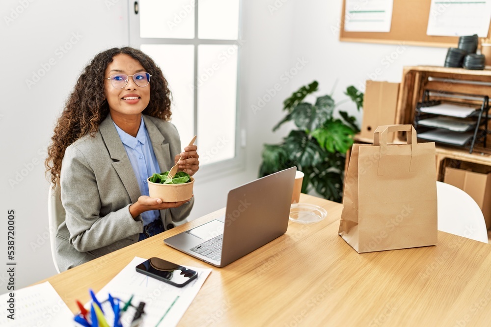 Young latin woman smiling confident eating salad at office Young latin woman smiling confident eating salad at office