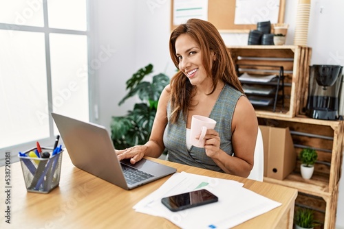 Free Download Young latin woman business worker using laptop and drinking coffee at office - GFXLoad