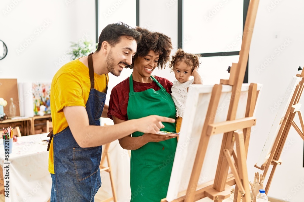 Couple and daughter smiling confident drawing at art studio Couple and daughter smiling confident drawing at art studio