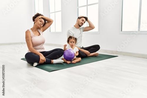 Couple and daughter stretching at sport center