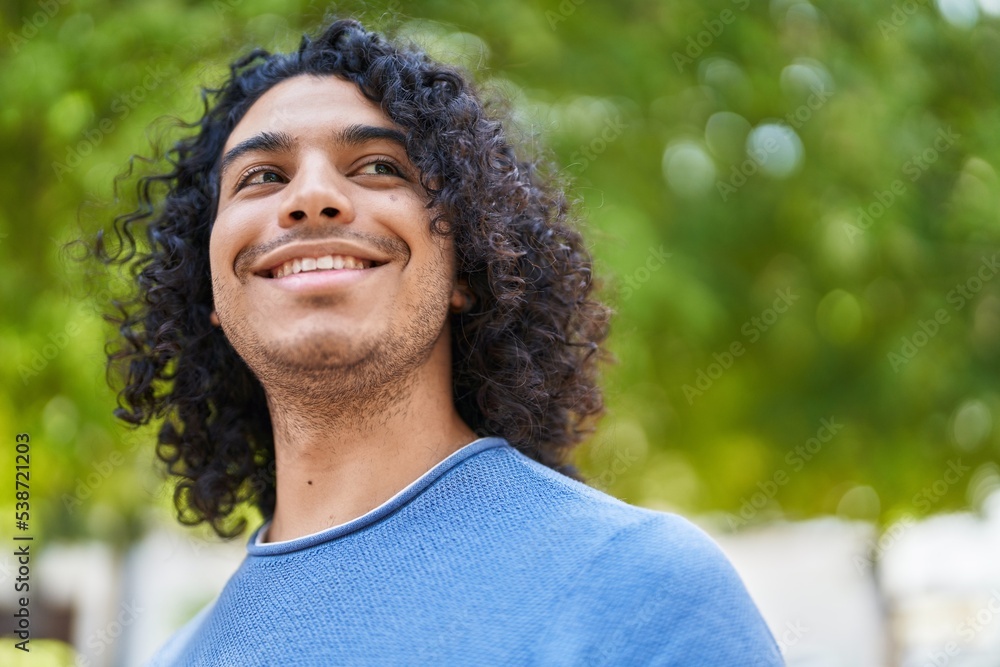 Young latin man smiling confident looking to the sky at park