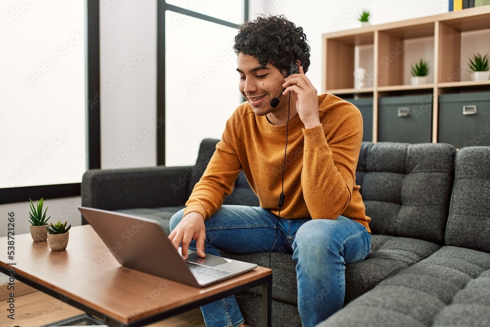 Young hispanic man having video call using laptop at home. Young hispanic man having video call using laptop at home.