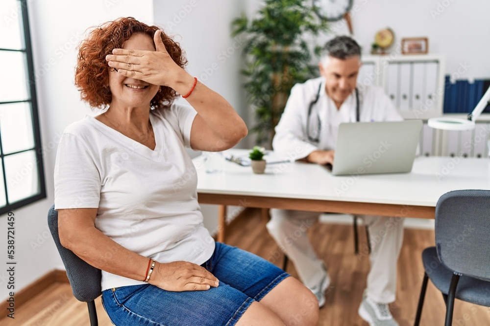 custom made wallpaper toronto digitalSenior woman sitting at doctor appointment smiling and laughing with hand on face covering eyes for surprise. blind concept.