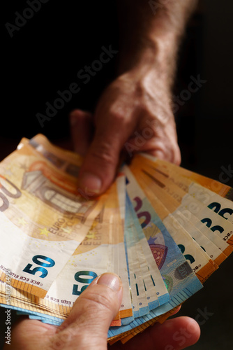 man handing euro banknotes to woman