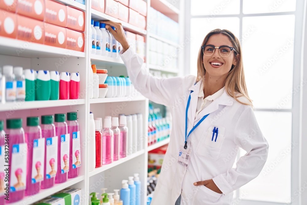Young blonde woman pharmacist smiling confident standing at pharmacy