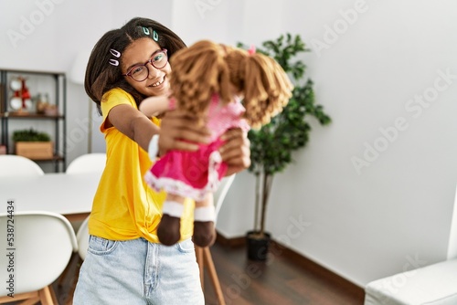 African american girl smiling confident holding doll at home