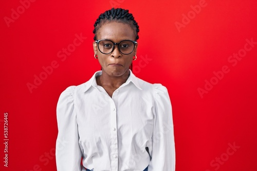 African woman with braids standing over red background depressed and worry for distress, crying angry and afraid. sad expression.