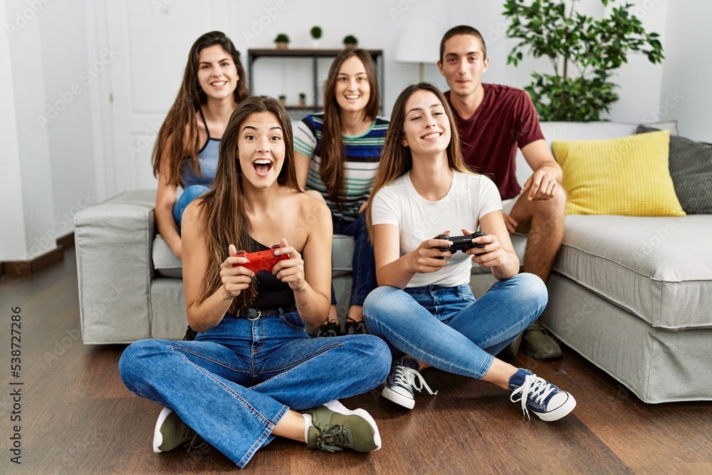 Group of young friends smiling happy playing video game at home. Group of young friends smiling happy playing video game at home.