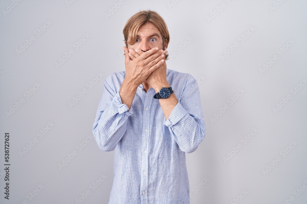 Caucasian man with mustache standing over white background shocked covering mouth with hands for mistake. secret concept. Caucasian man with mustache standing over white background shocked covering mouth with hands for mistake. secret concept.