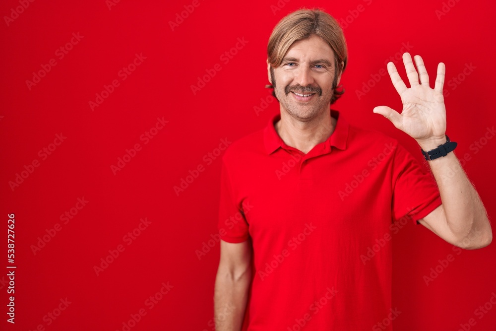 Caucasian man with mustache standing over red background showing and pointing up with fingers number five while smiling confident and happy. Caucasian man with mustache standing over red background showing and pointing up with fingers number five while smiling confident and happy.