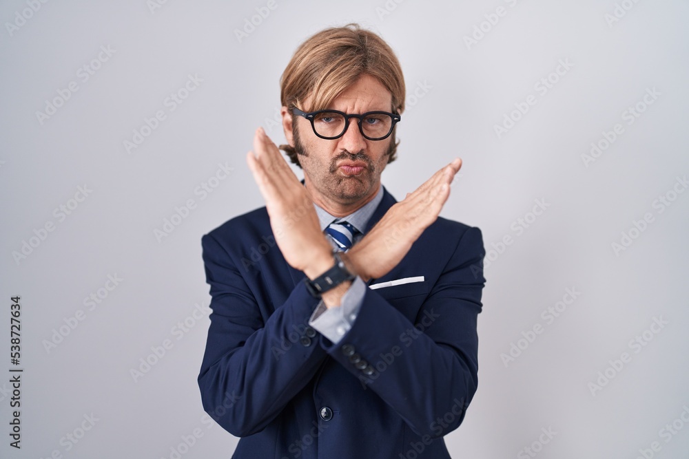 Caucasian man with mustache wearing business clothes rejection expression crossing arms doing negative sign, angry face Caucasian man with mustache wearing business clothes rejection expression crossing arms doing negative sign, angry face