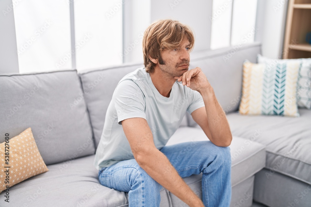 Young man stressed sitting on sofa at home Young man stressed sitting on sofa at home