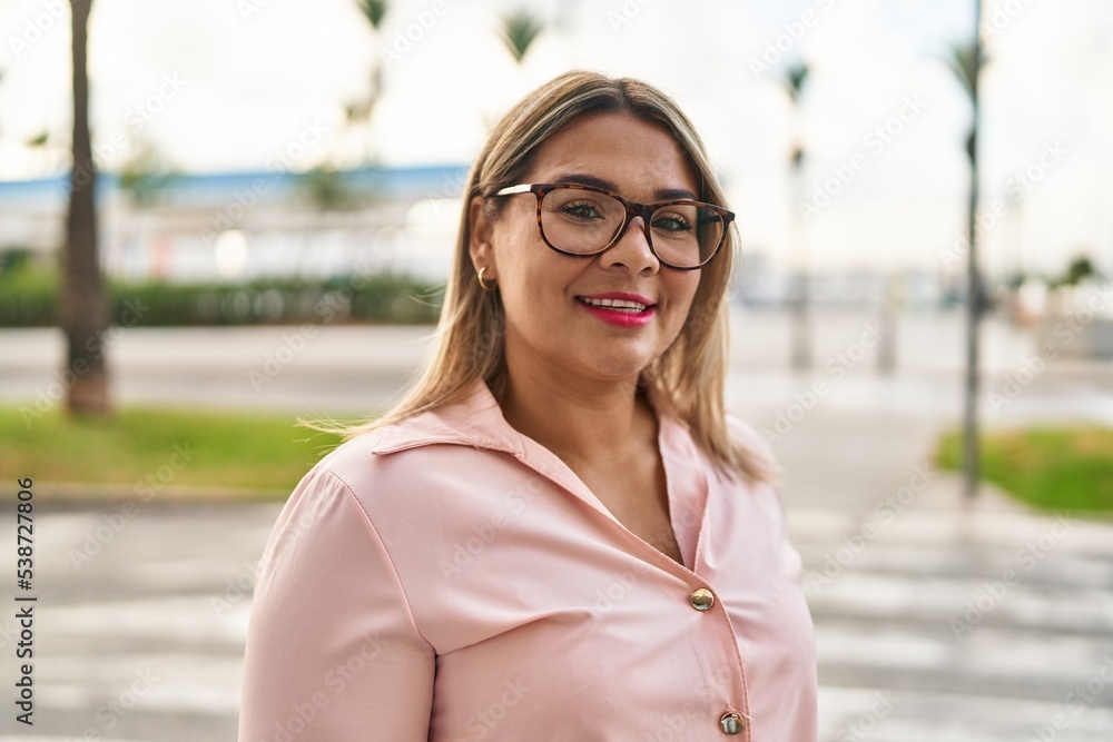Fototapeta premium Young hispanic woman smiling confident standing at street