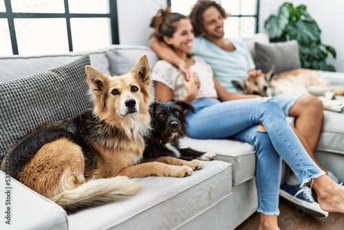 Canvas Print Man and woman couple smiling confident and hugging each other sitting on sofa wi