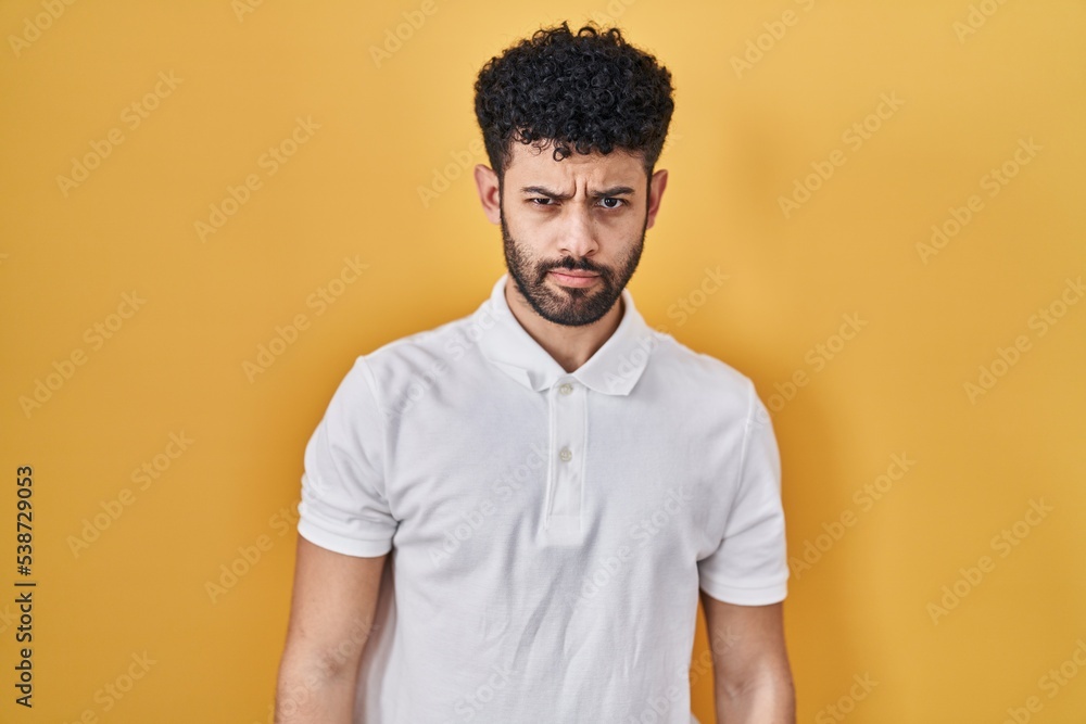 Arab man standing over yellow background skeptic and nervous, frowning upset because of problem. negative person. Arab man standing over yellow background skeptic and nervous, frowning upset because of problem. negative person.