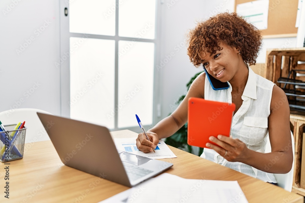 Young african american woman talking on the smartphone working at office Young african american woman talking on the smartphone working at office