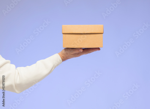 hands holding a gift box isolated. male and female hands holding give gift box on blue background isolated.christmas shopping gifts concept