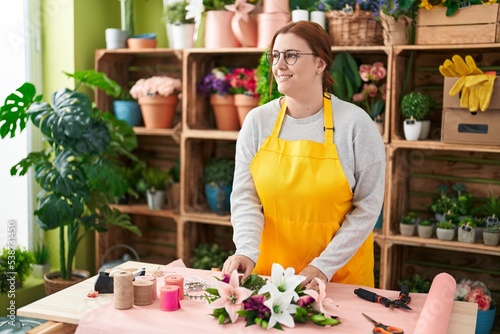 Young beautiful plus size woman florist make bouquet of flowers at flower shop
