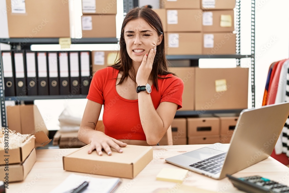 Young hispanic woman preparing order working at storehouse touching mouth with hand with painful expression because of toothache or dental illness on teeth. dentist concept. Young hispanic woman preparing order working at storehouse touching mouth with hand with painful expression because of toothache or dental illness on teeth. dentist concept.