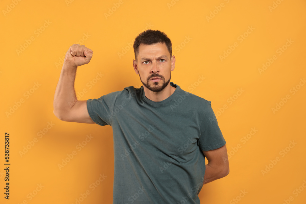 Man showing his fist on orange background Man showing his fist on orange background