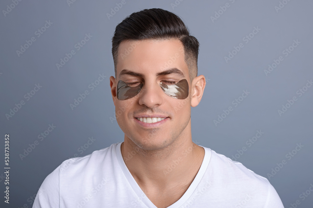 Man with dark under eye patches on grey background Man with dark under eye patches on grey background