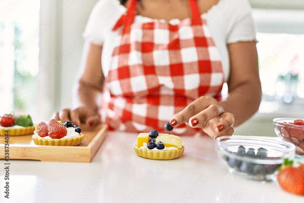 Hispanic brunette woman preparing pastries with fruits at the kitchen Hispanic brunette woman preparing pastries with fruits at the kitchen