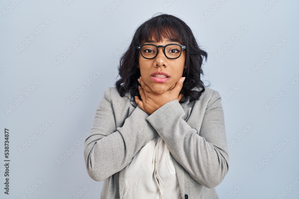 Hispanic woman standing over isolated background shouting and suffocate because painful strangle. health problem. asphyxiate and suicide concept. Hispanic woman standing over isolated background shouting and suffocate because painful strangle. health problem. asphyxiate and suicide concept.
