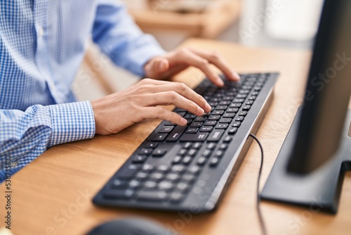 Young caucasian man using computer keyboard at office