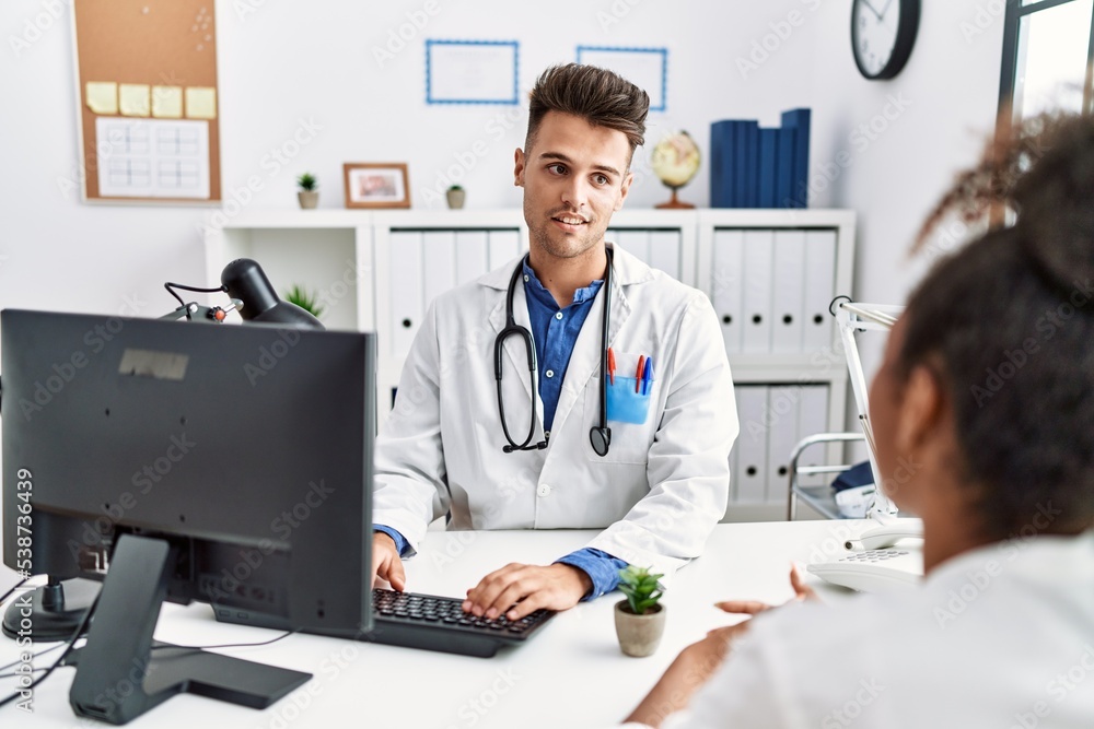 Man and woman wearing doctor uniform having medical consultation at clinic Man and woman wearing doctor uniform having medical consultation at clinic