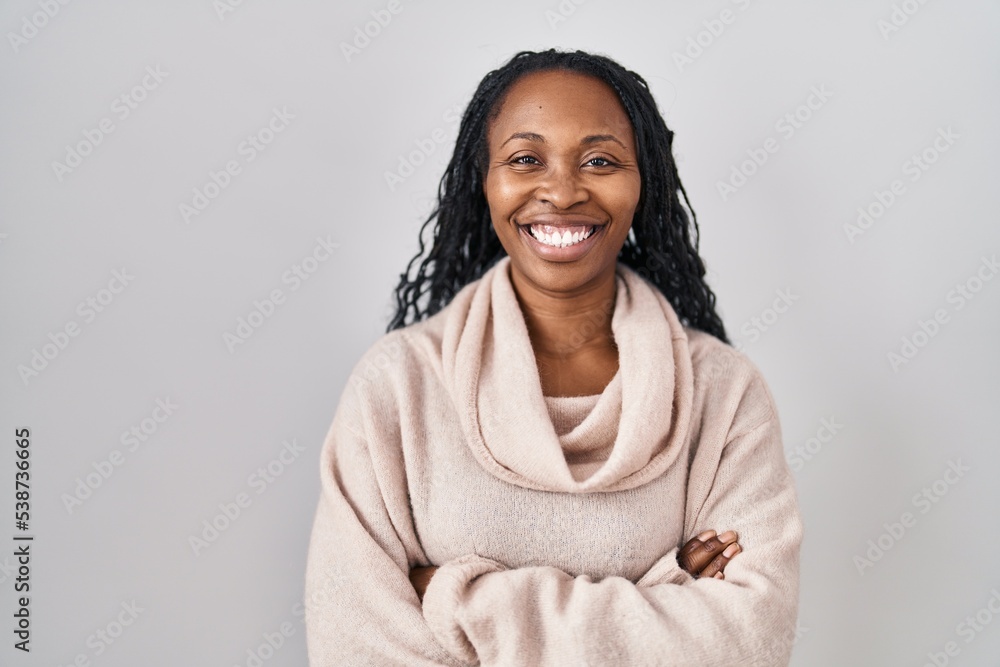 African woman standing over white background happy face smiling with crossed arms looking at the camera. positive person. African woman standing over white background happy face smiling with crossed arms looking at the camera. positive person.