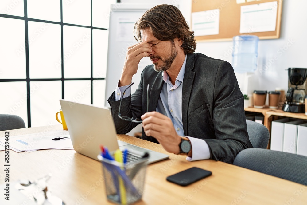 Middle age caucasian man stressed working at office Middle age caucasian man stressed working at office