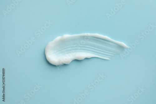 Sample of hand cream on light blue background, top view