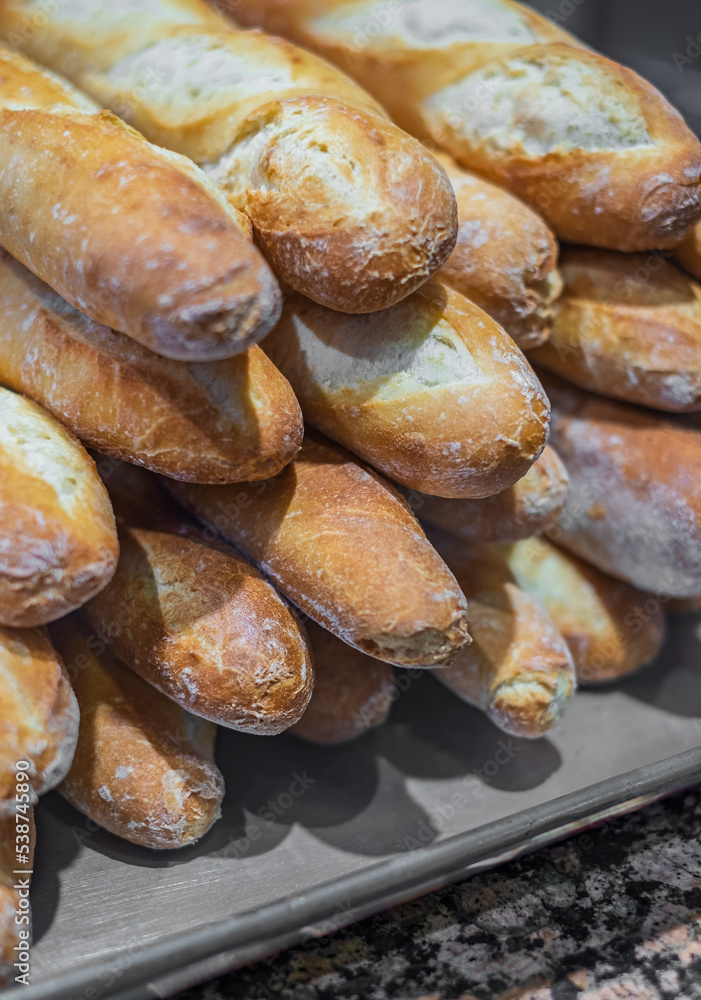 Freshly baked French baguettes in a bakery. Delicious Freshly baked breads Freshly baked French baguettes in a bakery. Delicious Freshly baked breads