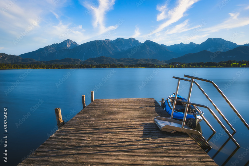 pier on the lake with mountains and clouds