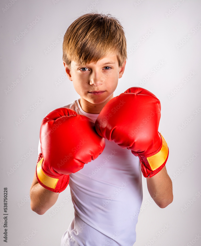 Male youth boxer boy with boxing gloves raised to defend his face Stock