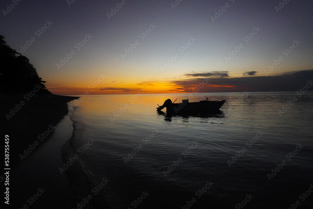 A Fishing Boat Anchored at Sunset