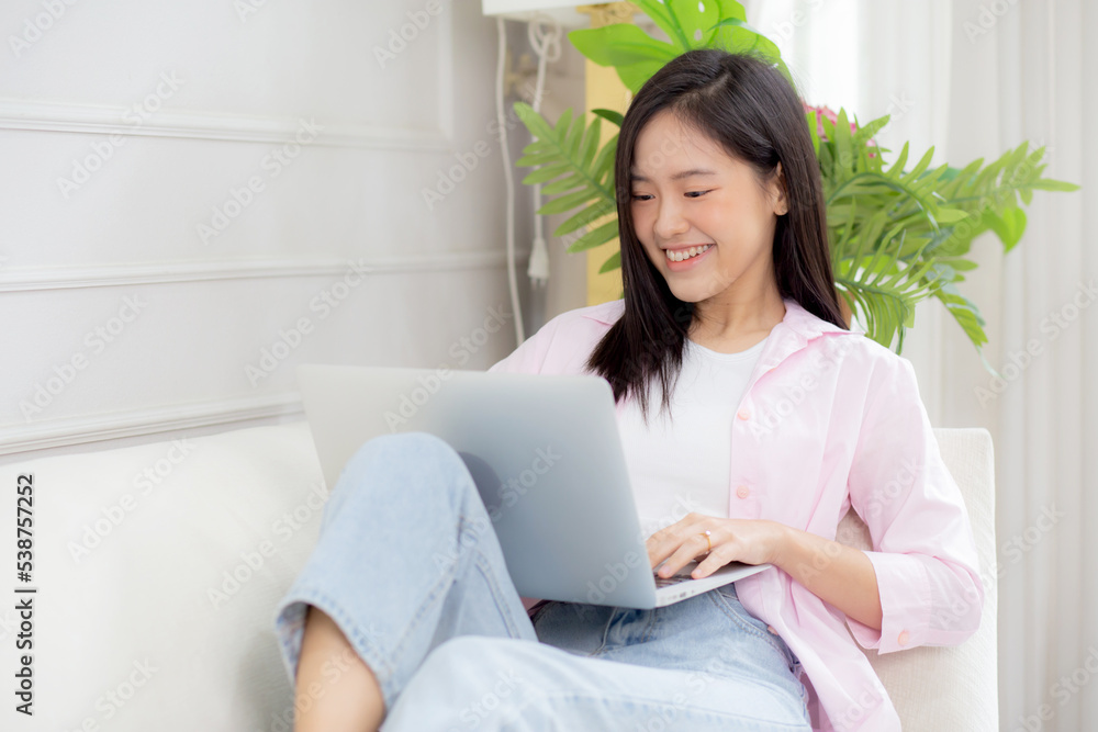 Young asian business woman work from home with laptop computer online to internet on sofa in living room, freelance girl using notebook sitting on couch with comfort and relax, lifestyles concept. Young asian business woman work from home with laptop computer online to internet on sofa in living room, freelance girl using notebook sitting on couch with comfort and relax, lifestyles concept.