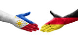 Handshake between Germany and Philippines flags painted on hands, isolated transparent image.