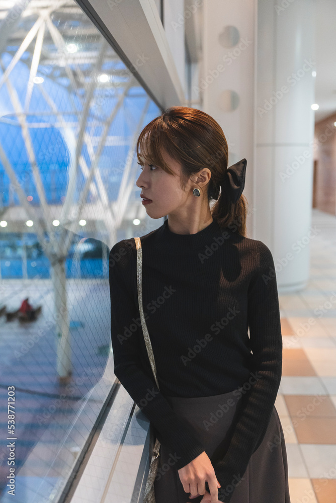 Fototapeta premium イルミネーションのあるビルにいる女性