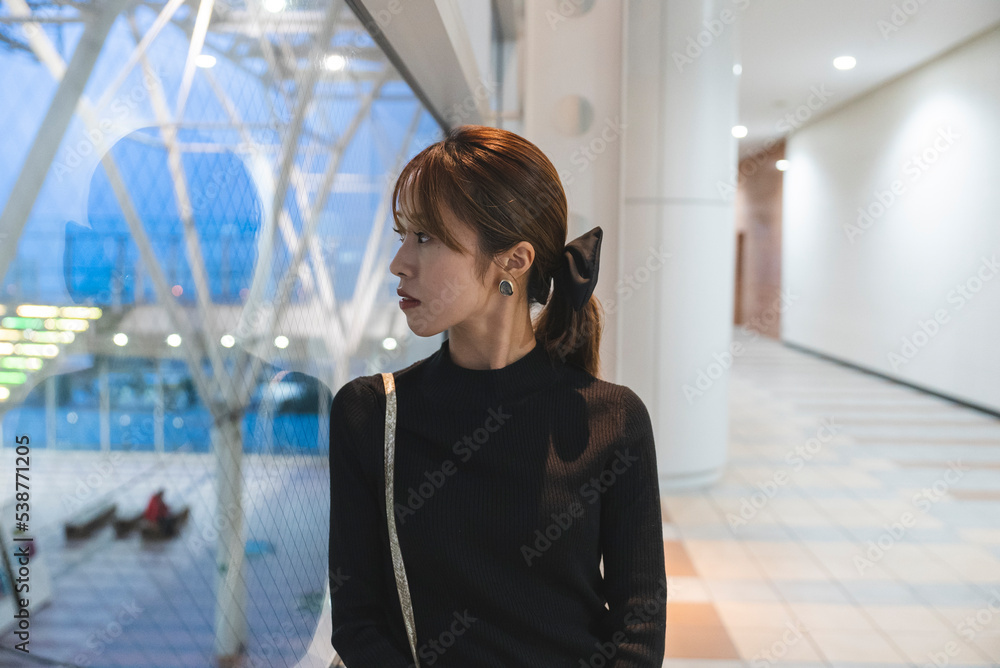 Fototapeta premium イルミネーションのあるビルにいる女性