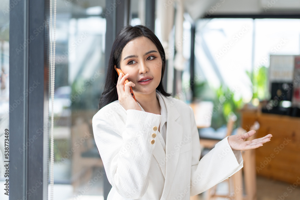 Asian woman with smartphone standing against street blurred building background. Asian woman with smartphone standing against street blurred building background.