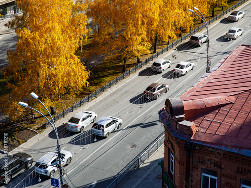 Aerial drone photograph of traffic jam in city in autumn day. Cars, buildng and trees photo