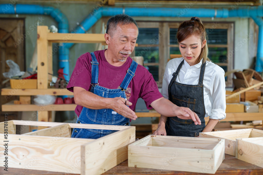 Tutor With Female Carpentry Student In Workshop Studying For Apprenticeship At College ,Teacher explaining a structure students while standing in a woodwork class Tutor With Female Carpentry Student In Workshop Studying For Apprenticeship At College ,Teacher explaining a structure students while standing in a woodwork class