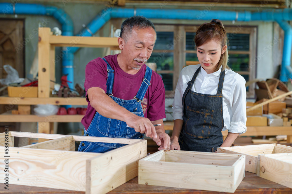 Tutor With Female Carpentry Student In Workshop Studying For Apprenticeship At College ,Teacher explaining a structure students while standing in a woodwork class Tutor With Female Carpentry Student In Workshop Studying For Apprenticeship At College ,Teacher explaining a structure students while standing in a woodwork class
