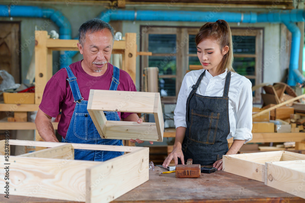 Tutor With Female Carpentry Student In Workshop Studying For Apprenticeship At College ,Teacher explaining a structure students while standing in a woodwork class Tutor With Female Carpentry Student In Workshop Studying For Apprenticeship At College ,Teacher explaining a structure students while standing in a woodwork class