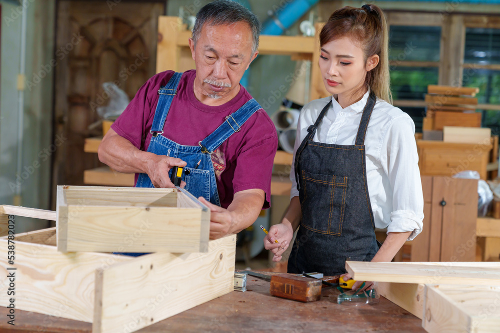 Tutor With Female Carpentry Student In Workshop Studying For Apprenticeship At College ,Teacher explaining a structure students while standing in a woodwork class Tutor With Female Carpentry Student In Workshop Studying For Apprenticeship At College ,Teacher explaining a structure students while standing in a woodwork class