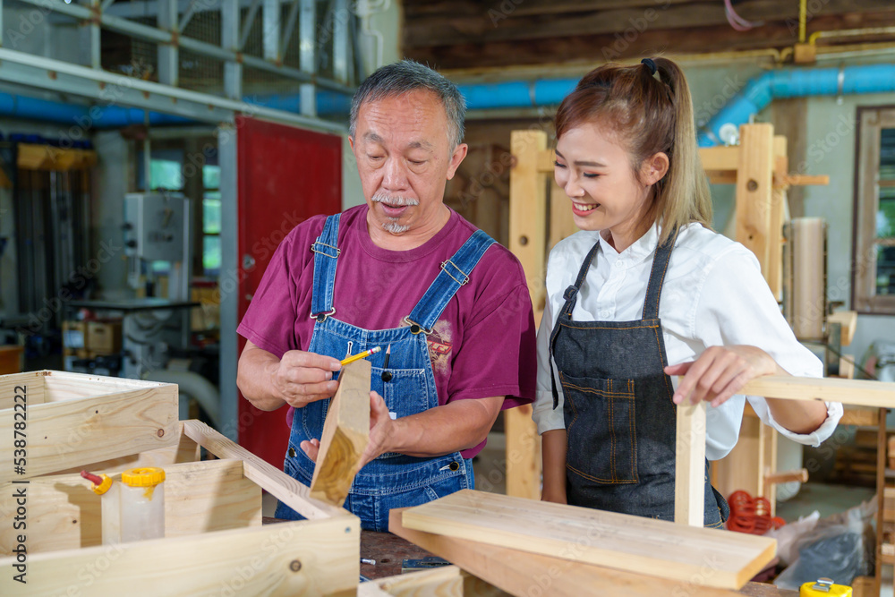 Teacher explaining a structure students while standing in a woodwork class Teacher explaining a structure students while standing in a woodwork class