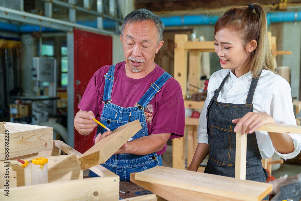 Teacher explaining a structure students while standing in a woodwork class Teacher explaining a structure students while standing in a woodwork class